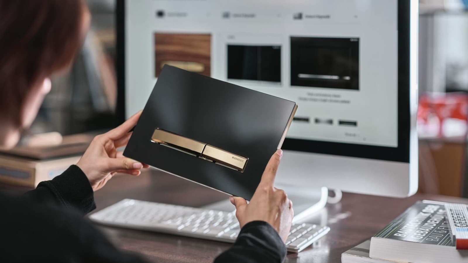 Sieviete ar Geberit Sigma50 noskalošanas paneli ar pogu rozā zelta krāsā Sieviete ar Geberit Sigma50 noskalošanas paneli ar pogu rozā zelta krāsā